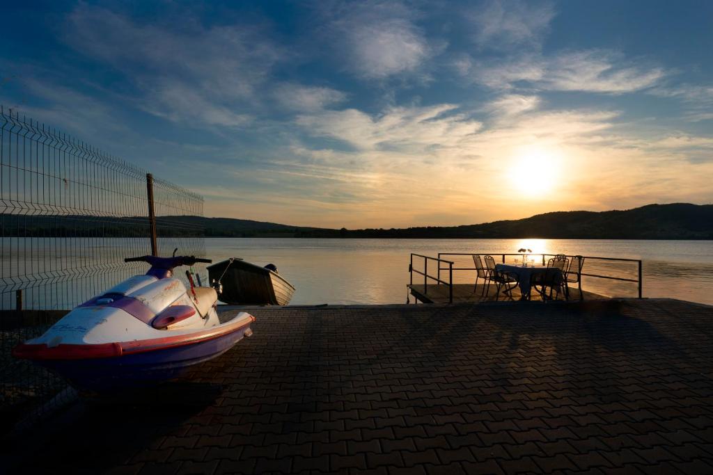 a boat sitting on the shore of a lake at Casa LaMal in Divici