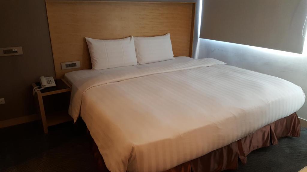 Postel nebo postele na pokoji v ubytování 麗馨商旅七賢館