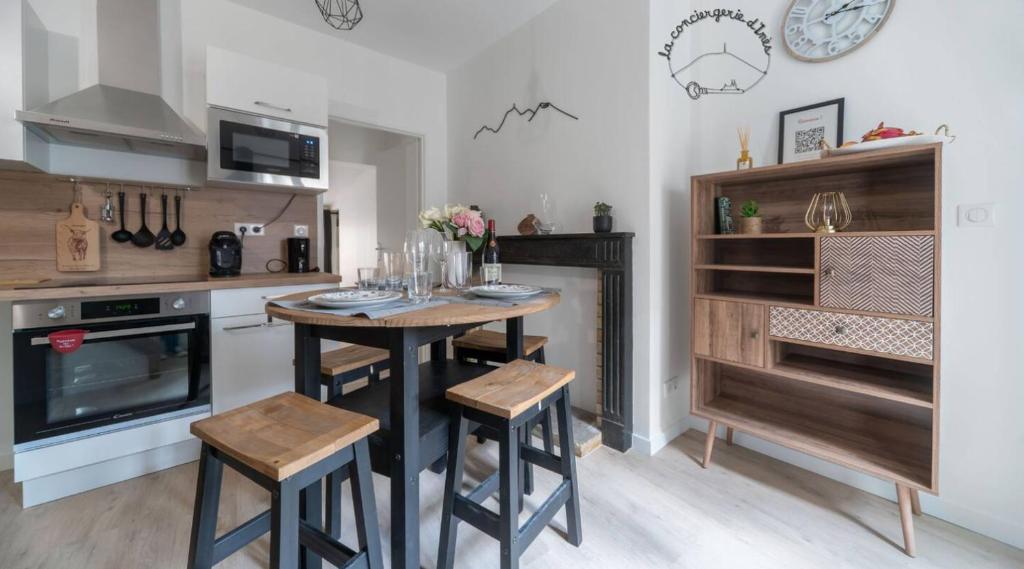 a kitchen with a table and some chairs and a stove at L'Evasion Urbaine #Hypercentre#Confort in Clermont-Ferrand