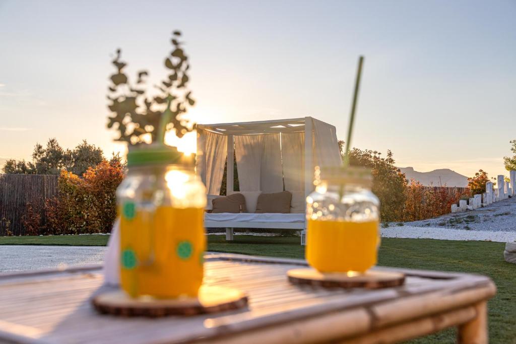 two bottles of orange juice sitting on a wooden table at Complejo Cuevas Otto in Baza