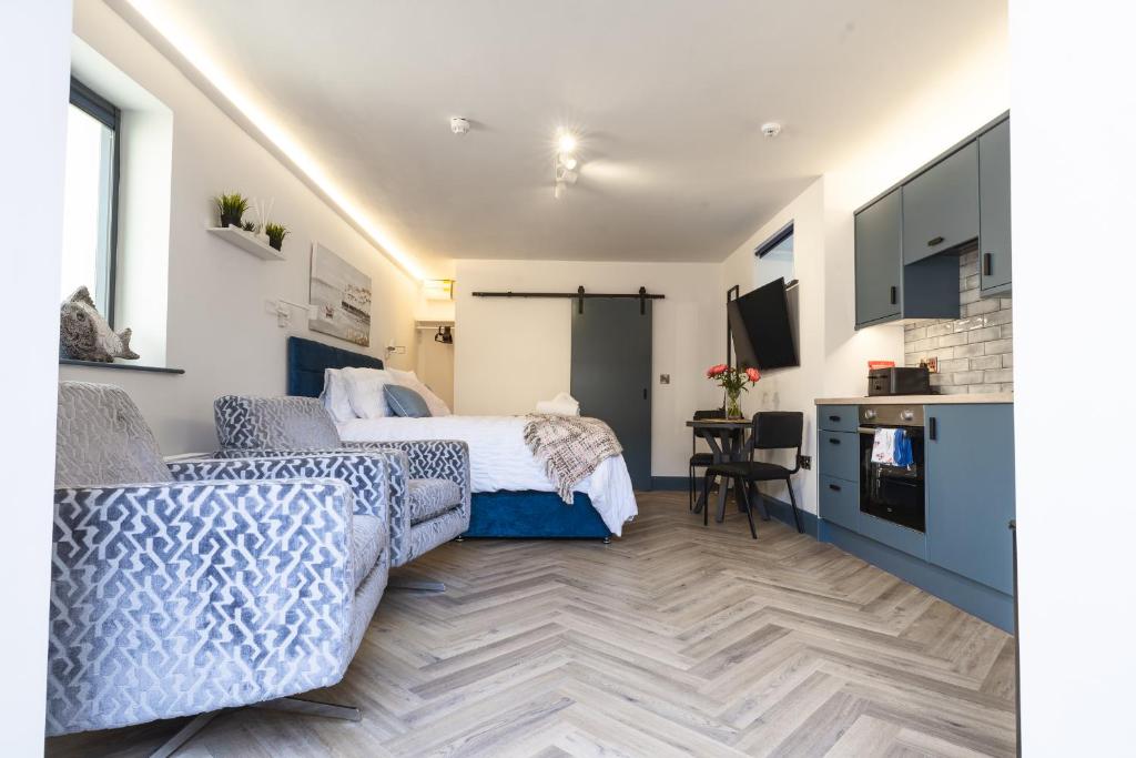 a bedroom with a bed and a desk and a kitchen at Luxury & Cozy Tourist Base in Bushmills