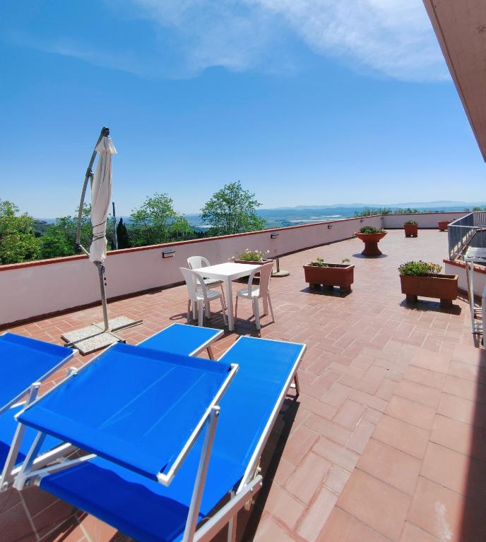 a patio with blue tables and chairs on a roof at Appartamento Tuttiventi in Campiglia Marittima