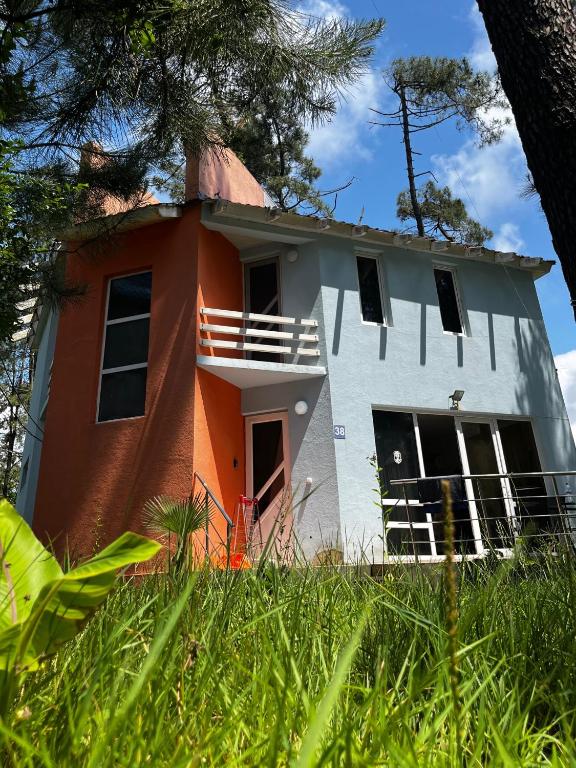 a white and orange house in the grass at Villa Ultima Grigoleti in Lanch'khut'i