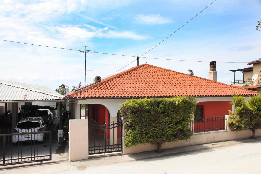 a house with a red roof and a fence at Villa Tzekos in Epanomi