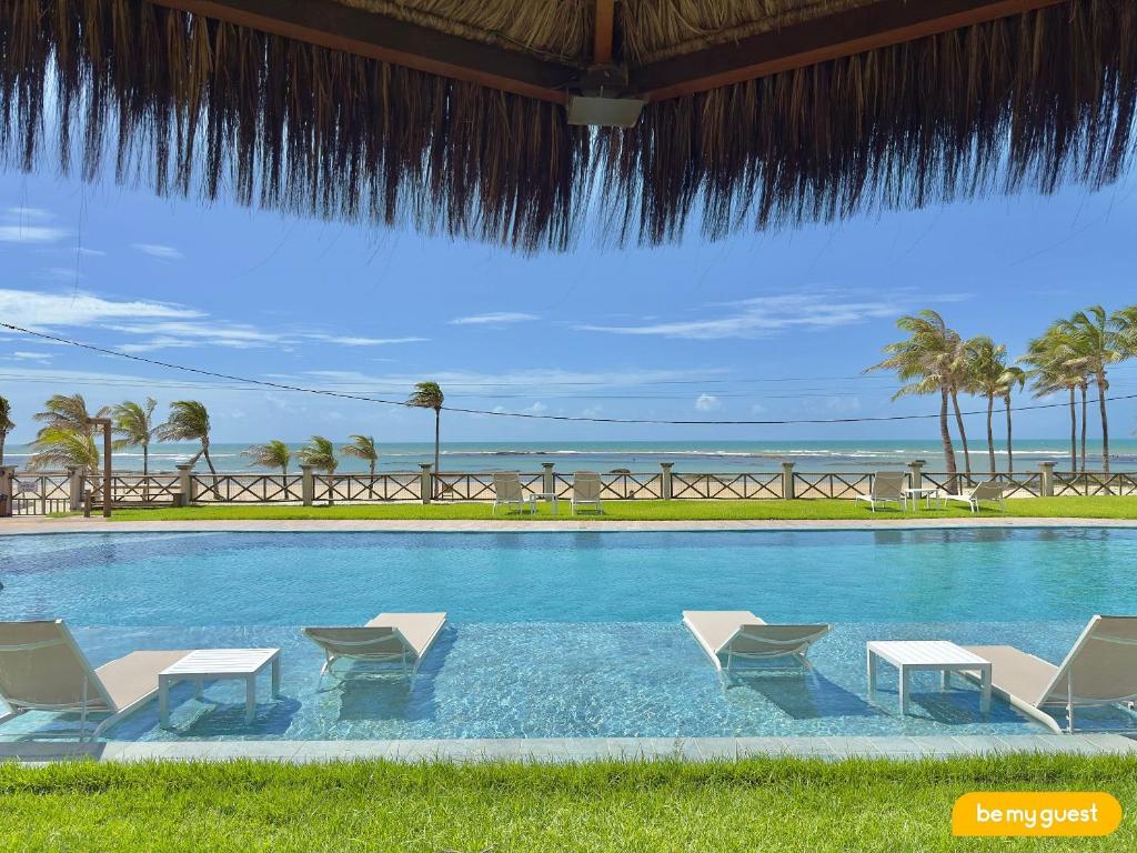 a swimming pool with chairs and a view of the ocean at Pier 18 - Flecheiras in Flecheiras
