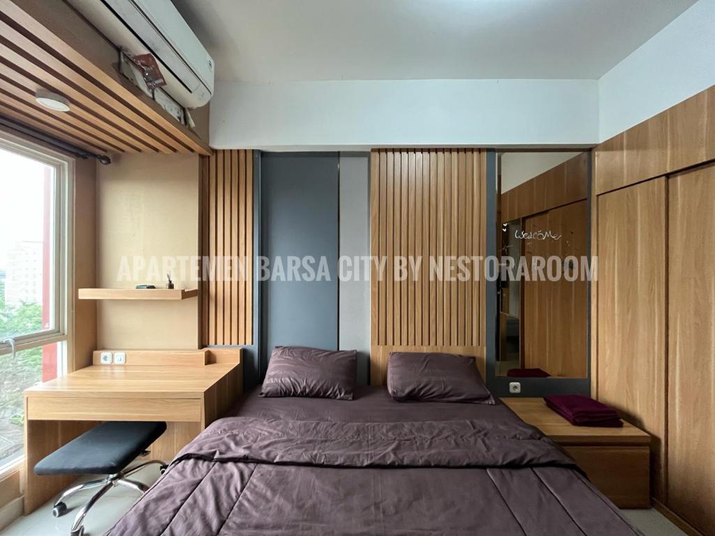 une chambre avec un lit et un bureau dans l'établissement Apartemen Barsa City ByNestoraroom, à Seturan