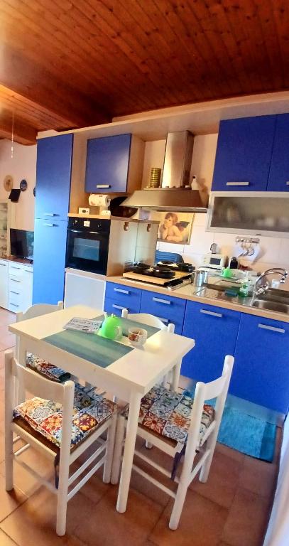 a kitchen with a white table and some blue cabinets at Il nido in collina Bertinoro in Bertinoro