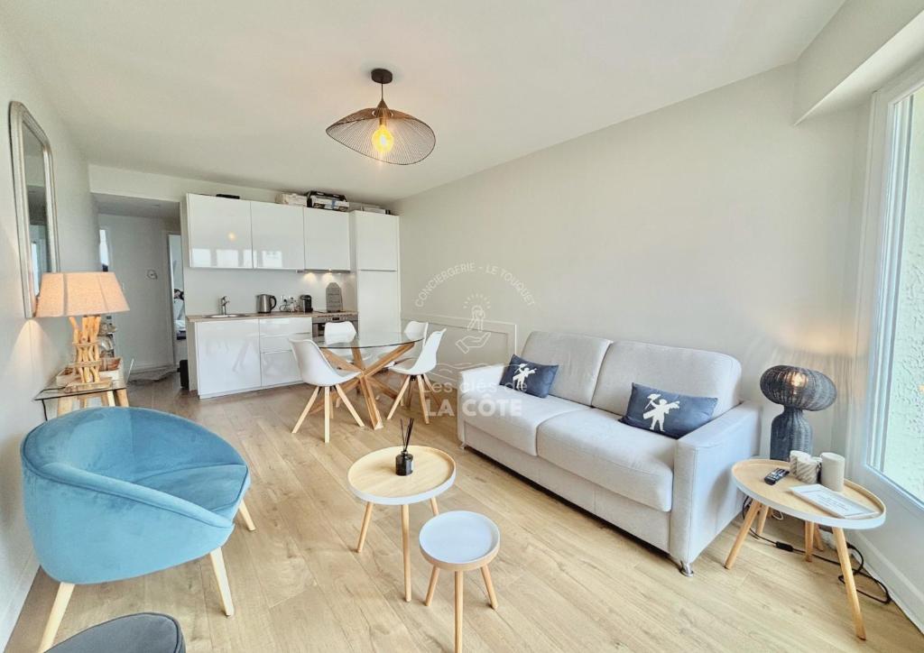 un salon avec un canapé et une table dans l'établissement Le Bedford, à Le Touquet-Paris-Plage