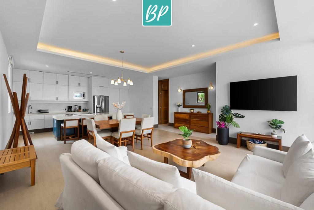 a living room with a white couch and a table at QUIYA - Luxury Condos with Exclusive Beach Club in Cruz de Huanacaxtle