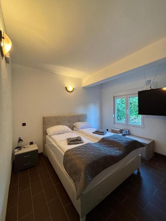 a bedroom with two beds and a flat screen tv at Apartment Anna-Nikola Igalo in Igalo