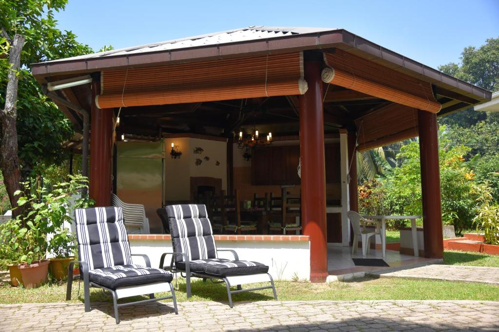 dos sillas bajo un cenador en Jessies Guest House Seychelles, en Beau Vallon