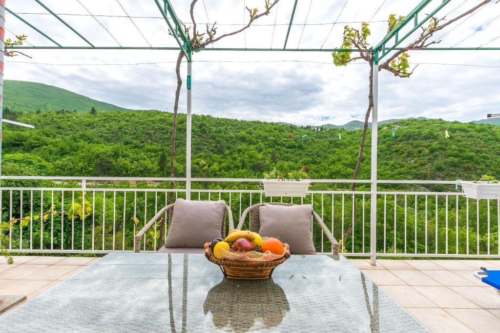 a bowl of fruit on a glass table on a balcony at Apartment Green view in Slime