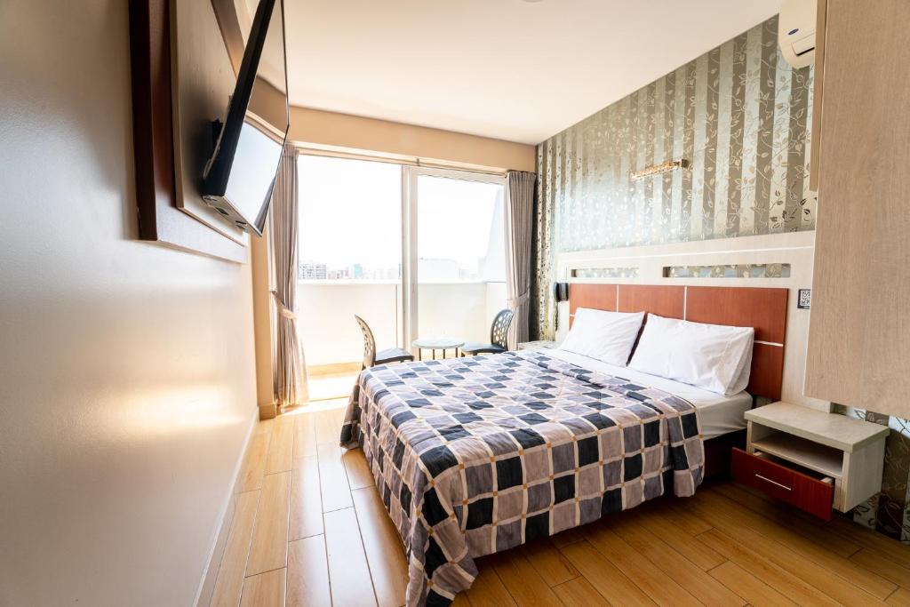 um quarto de hotel com uma cama e uma janela em Quadrum em Lima