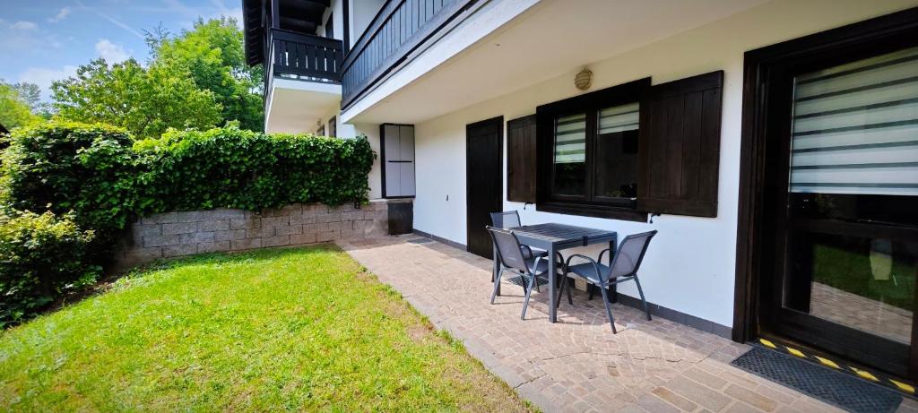 a patio with a table and chairs in front of a house at Casa Cermis in Cavalese