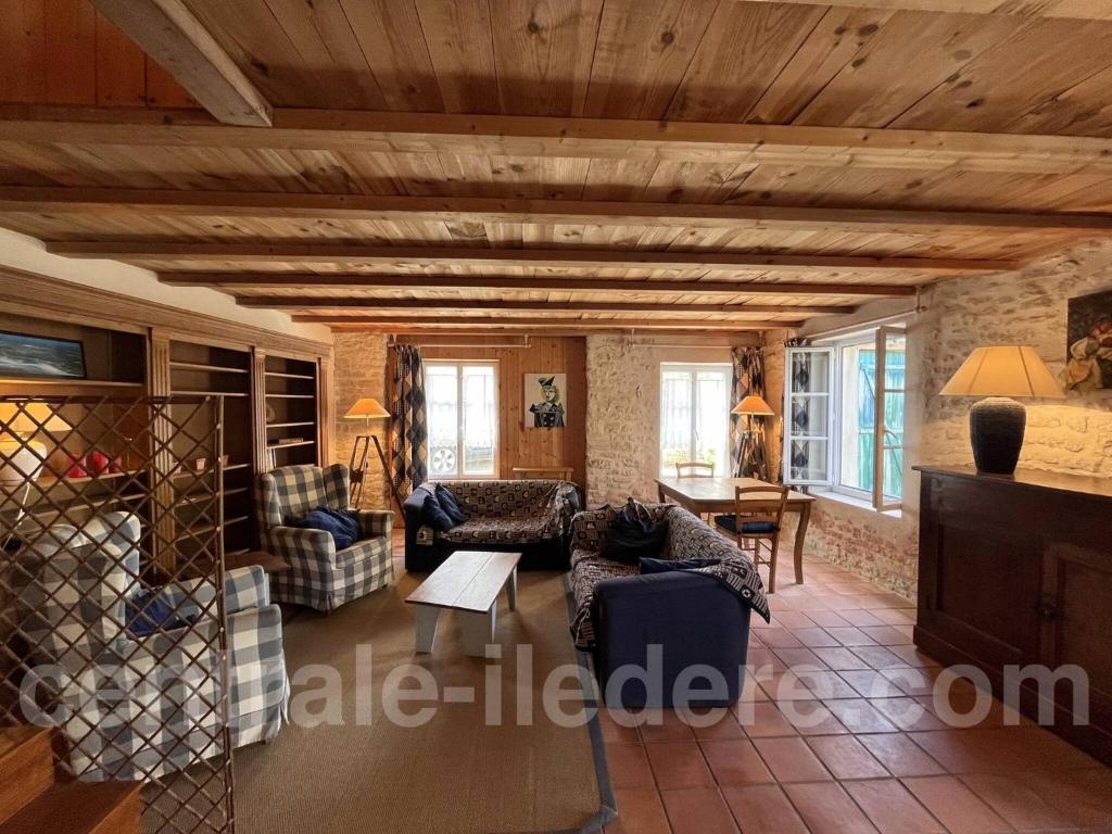 een woonkamer met een bank en een tafel bij La Villa de la Clairiere in Le Bois-Plage-en-Ré