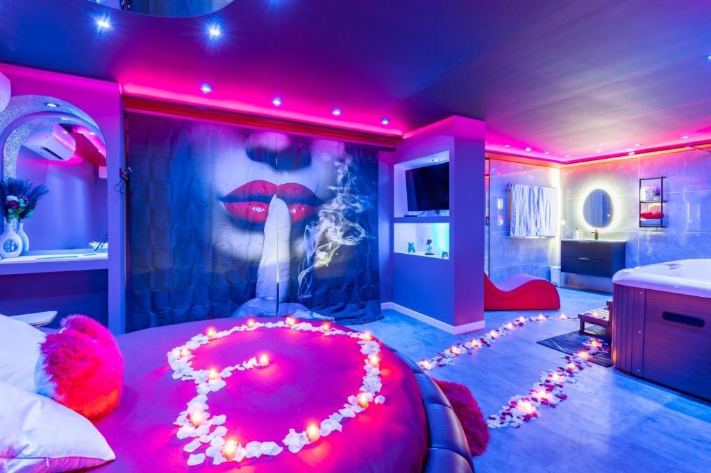 ein Schlafzimmer mit einem großen roten Bett mit einem Lippengemälde in der Unterkunft Secret Night Pamiers in Pamiers