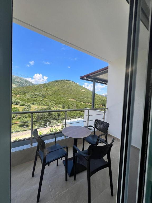 a balcony with a table and chairs and a view at Athina Rooms in Himare