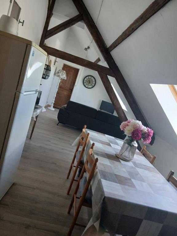 a kitchen with a table with a vase of flowers on it at La cabane de Lancelot Loubliette in Laperrière-sur-Saône