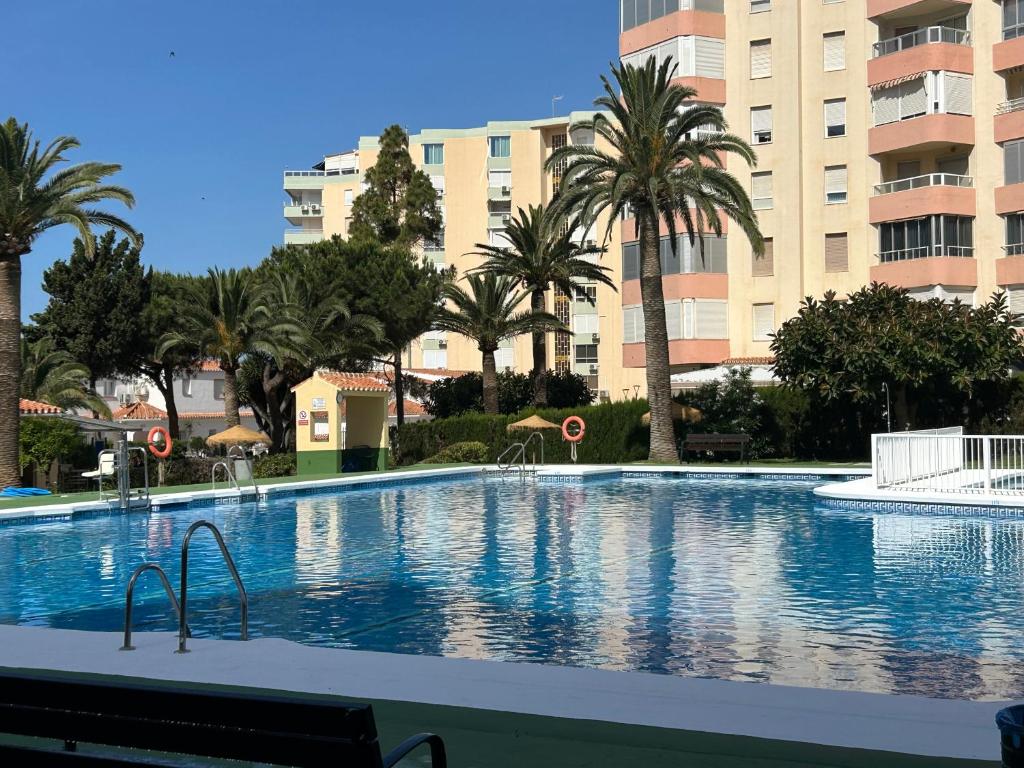 duży basen z palmami i budynkami w obiekcie Casa Del Caballito De Mar w Maladze