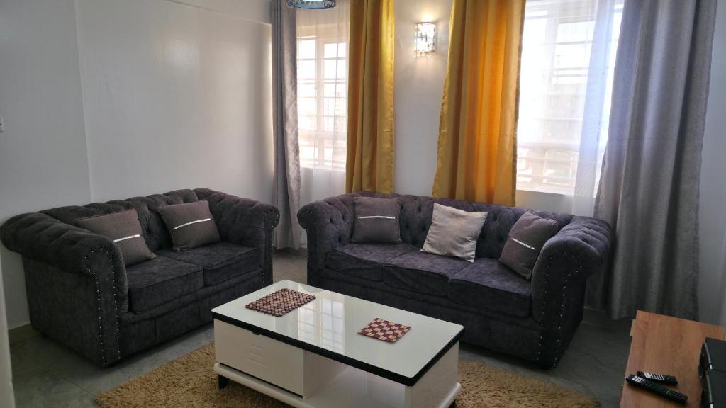ein Wohnzimmer mit zwei Sofas und einem Couchtisch in der Unterkunft Cozy homes in ruiru, OJ in Gatunga