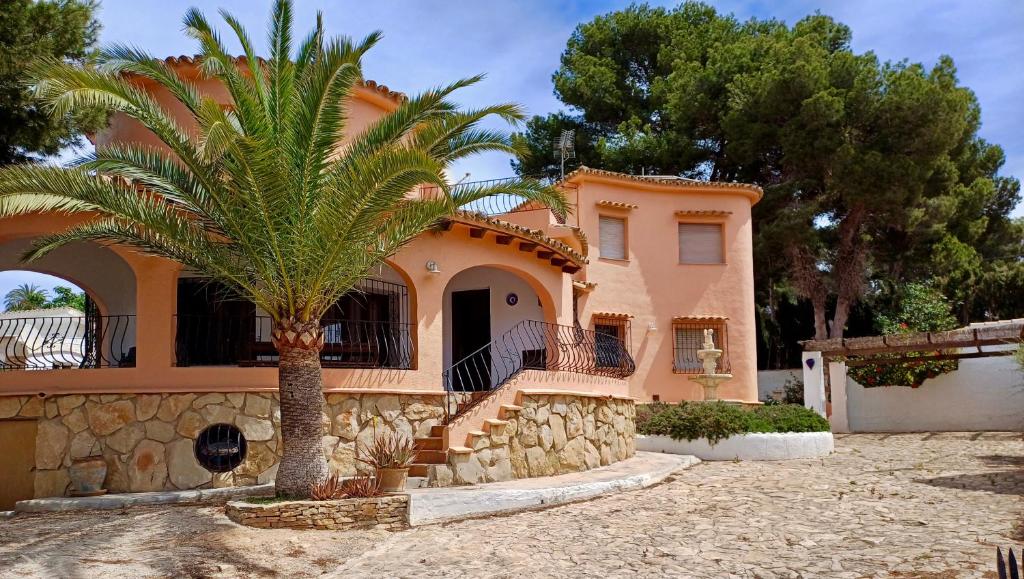 a house with a palm tree in front of it at La Font Moraira in Moraira