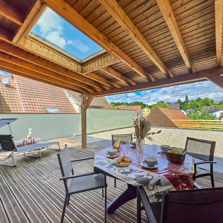 un patio avec une table et des chaises sur une terrasse dans l'établissement Niederhaslach - Havre de paix alsacien idéal pour familles et déconnexion, à Niederhaslach