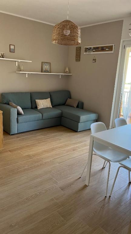 a living room with a blue couch and a table at Enhorabona Beach House in Alghero