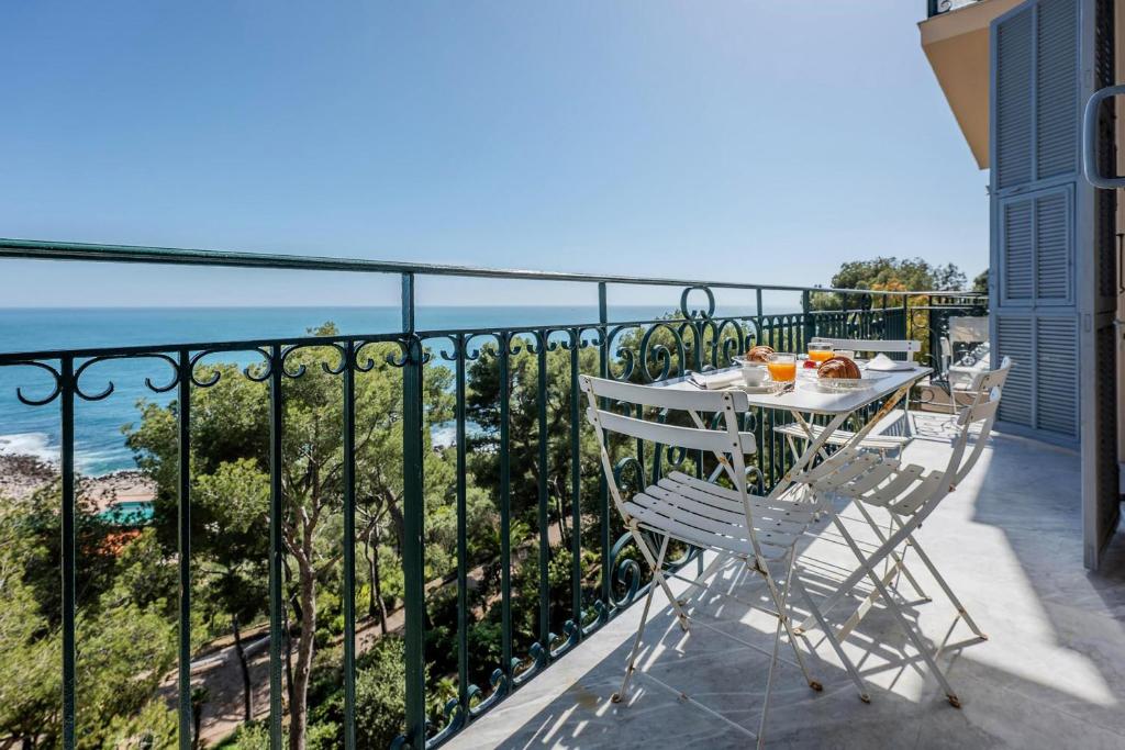 un balcon avec une table et des chaises et l'océan dans l'établissement Cap Martin, à Roquebrune-Cap-Martin