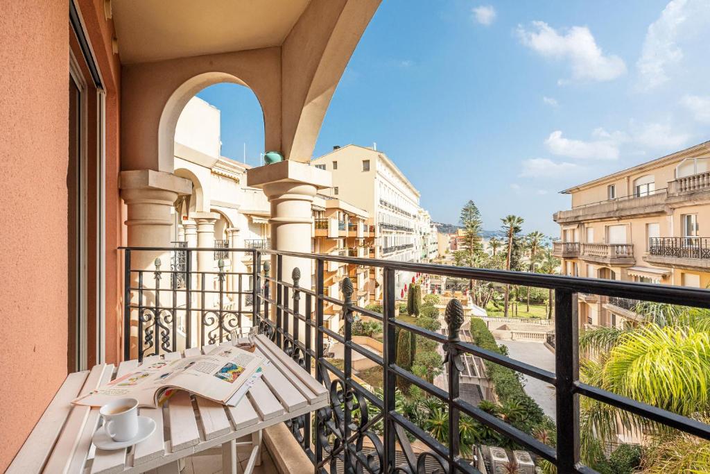 d'un balcon avec une table et une vue sur la rue. dans l'établissement Queen Garden - Happy Rentals, à Menton