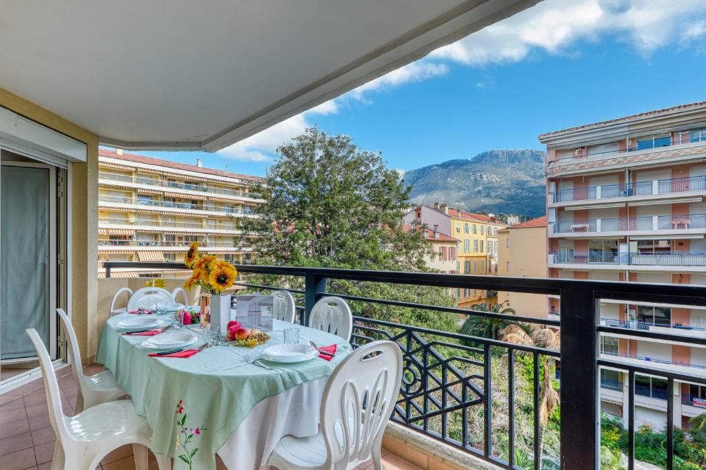 une table sur un balcon avec vue sur une ville dans l'établissement Garden View Daturas - Happy Rentals, à Menton