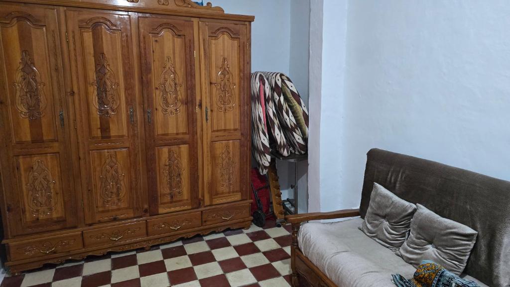 a large wooden cabinet in a living room with a couch at Merhaba in Chefchaouen