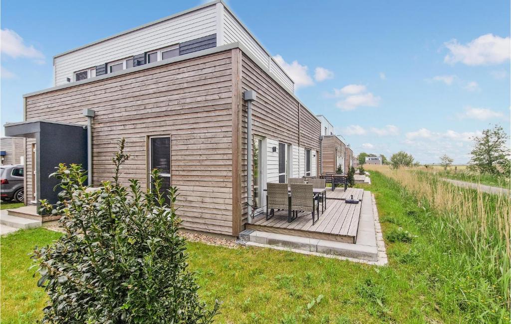 ein kleines Haus mit einer Terrasse im Gras in der Unterkunft Puettenhuus in Tossenserdeich