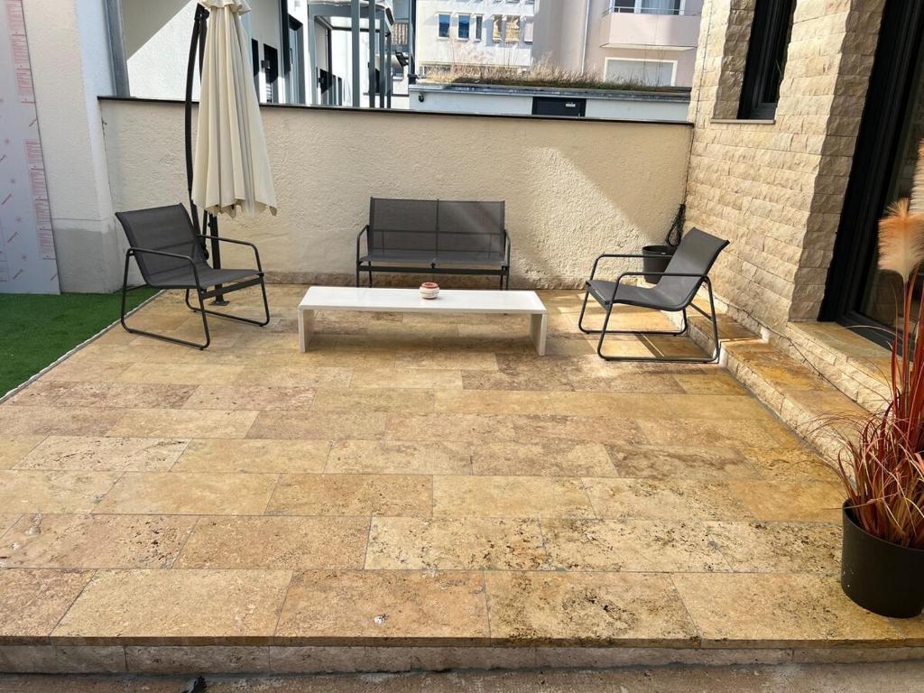 a patio with two chairs and a table and an umbrella at To&To Apartments 1 Bedroom in Stuttgart