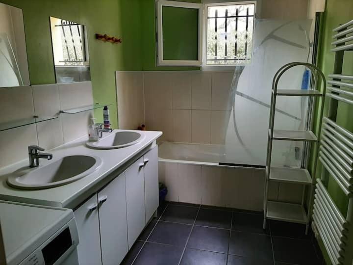 une salle de bain avec deux lavabos et une baignoire dans l'établissement Lepin House, à Lazer