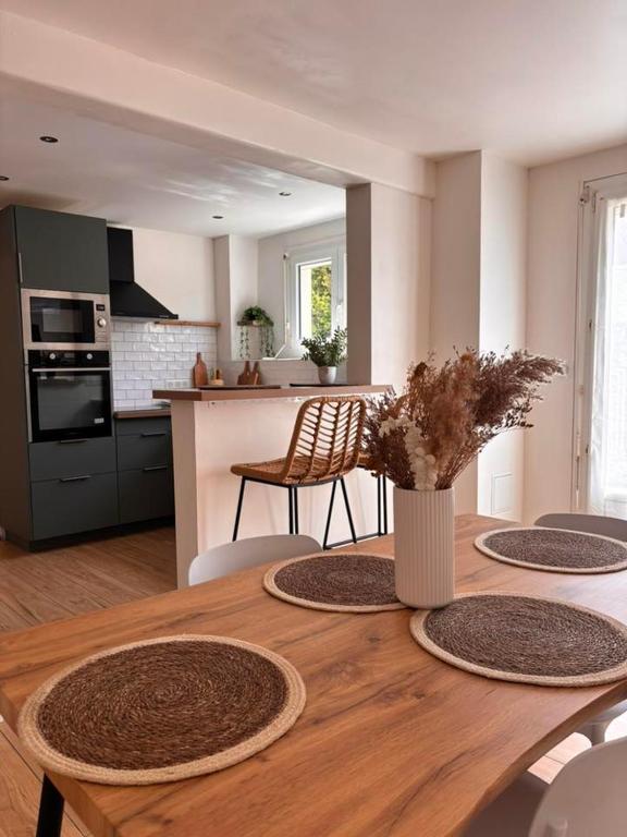 une cuisine et une salle à manger avec une table en bois et des chaises dans l'établissement Maison de vacances, à Saint-Laurent-de-la-Salanque