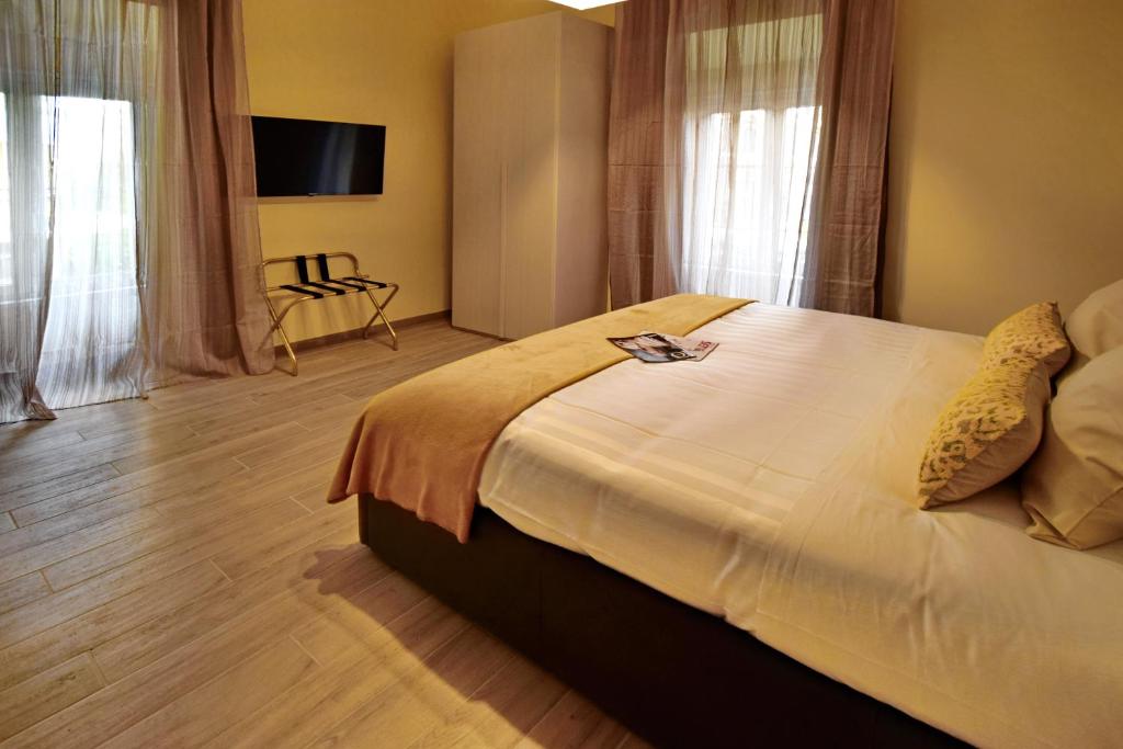 a bedroom with a large bed with a tv on the wall at CdR Guest House in Rome