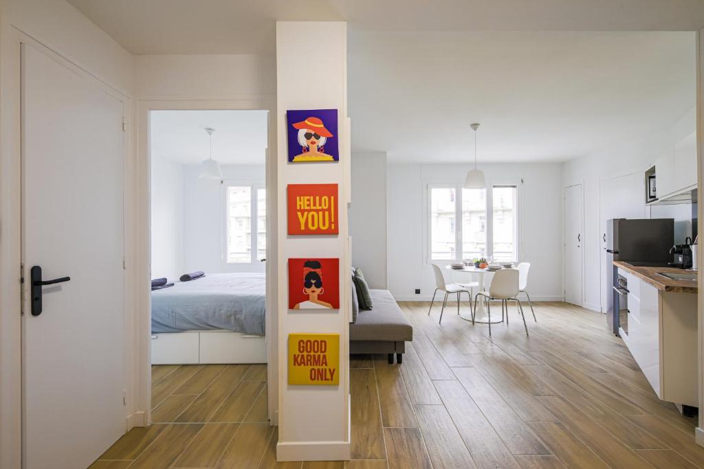 une chambre blanche avec un lit, une cuisine et un salon dans l'établissement T2 rénové hyper centre vue dégagée, à Grenoble