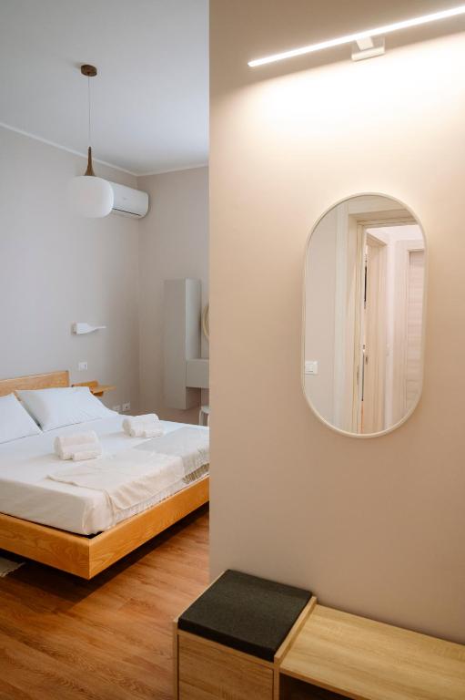 ein Schlafzimmer mit einem Bett und einem Spiegel an der Wand in der Unterkunft Calabreeze in Villa San Giovanni