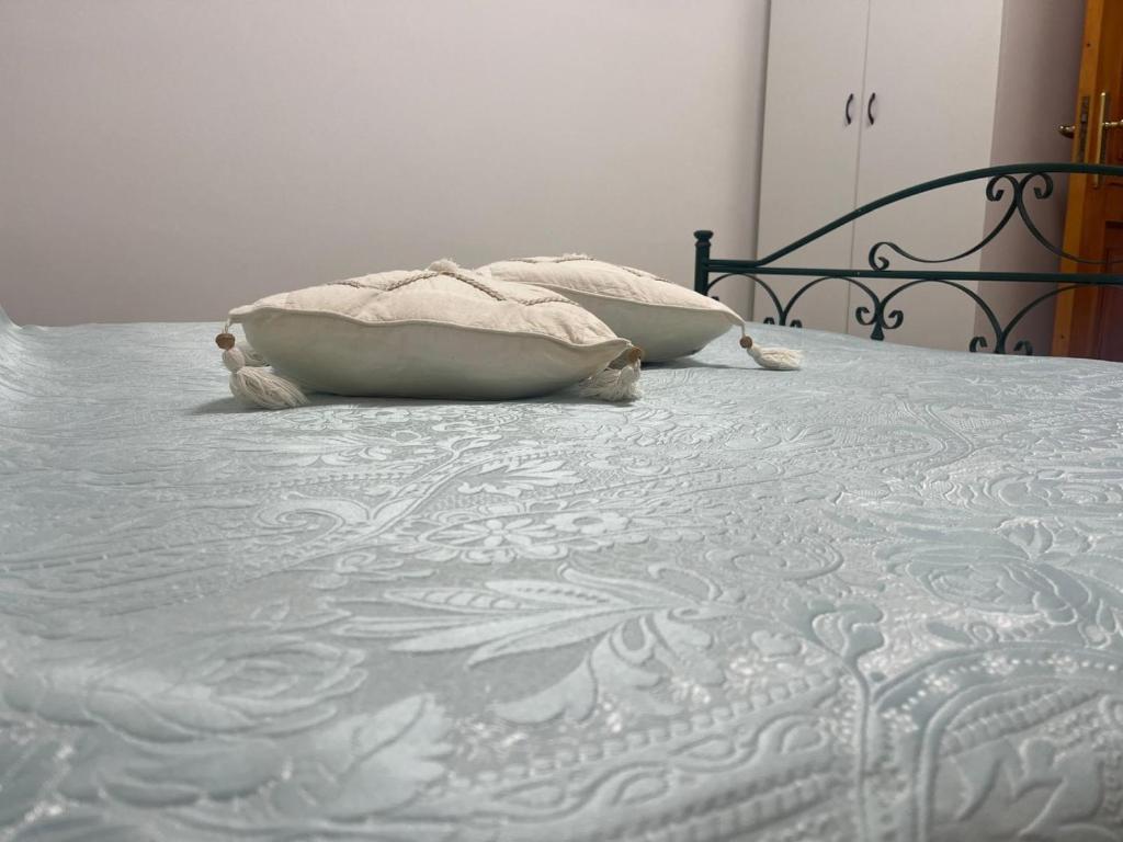 a bed with two pillows sitting on top of it at Giardino di Chiara al mare in Torre Rinalda