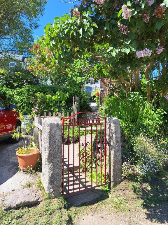 a metal gate in a garden with flowers at Redmoor in Saint Day