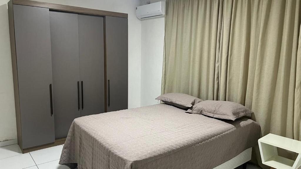 a small bedroom with a bed and a closet at Apartamento 3 min do FIG in Garanhuns