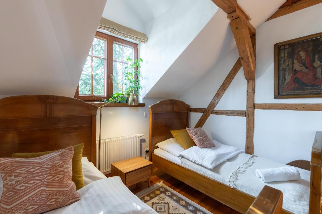 pokój na poddaszu z dwoma łóżkami i oknem w obiekcie Apartamenty Batur w mieście Karpacz