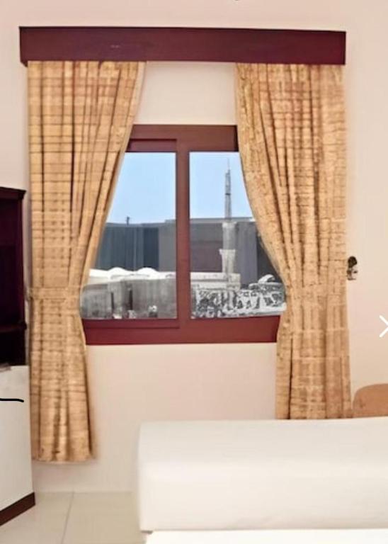 a window with a view of a city at فندق مراج طيبه Mirage Taiba Hotel in Medina