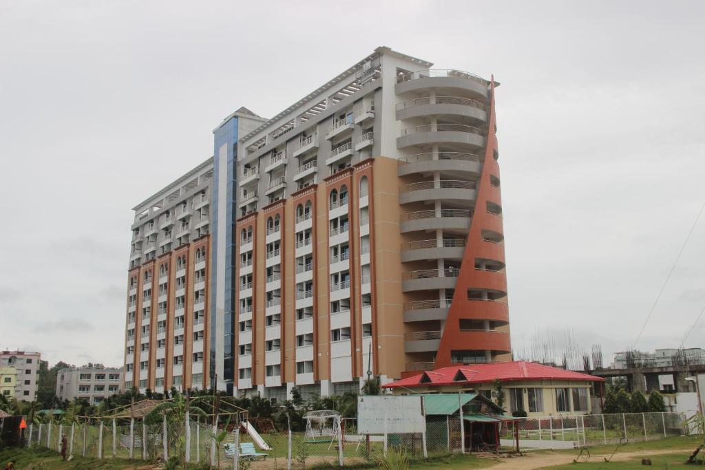 a large apartment building with a tall building at Sea Princess Hotel in Cox's Bazar