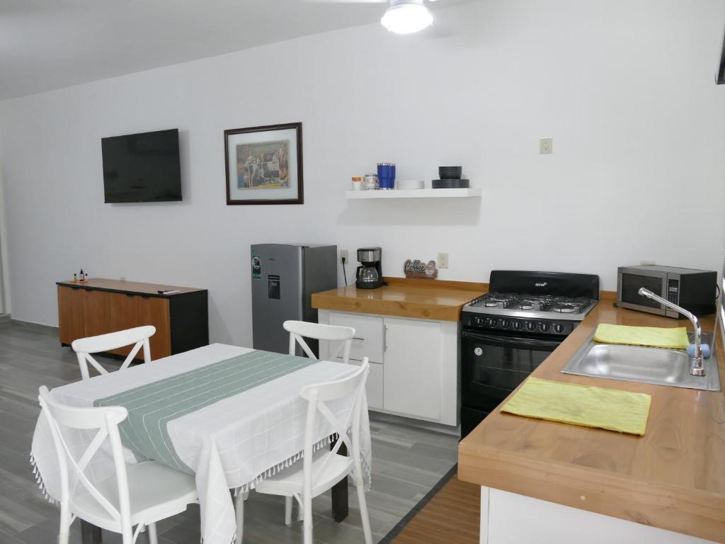 eine Küche mit einem Tisch, einem Herd und einer Spüle in der Unterkunft Majahuas Estudios in San-Blas-Inseln