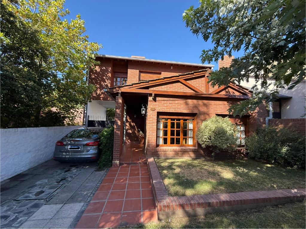 ein Backsteinhaus mit einem davor geparkten Auto in der Unterkunft Casa del Bicentenario in Tandil