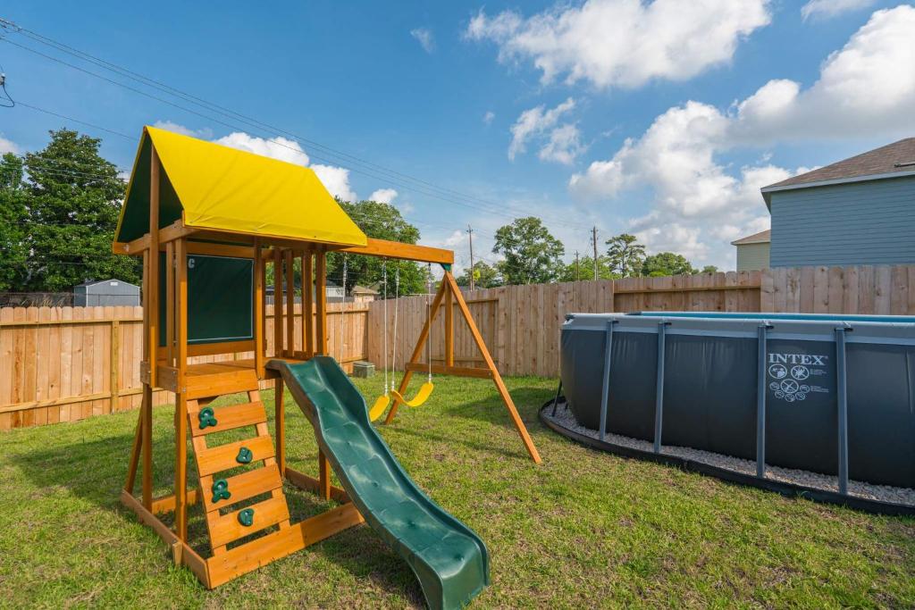 a playground with a slide and a play house at Pool house with hot tub in Houston