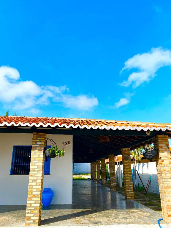 a brick building with a roof on a beach at Dunas House in Luis Correia