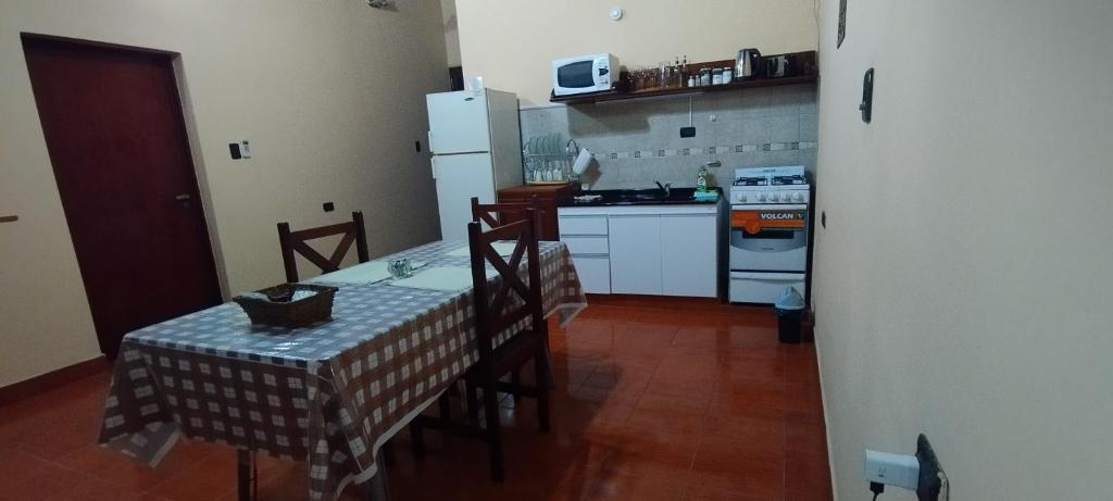 a kitchen with a table and a white refrigerator at Alojamiento Temporal MartinaS in San Fernando del Valle de Catamarca