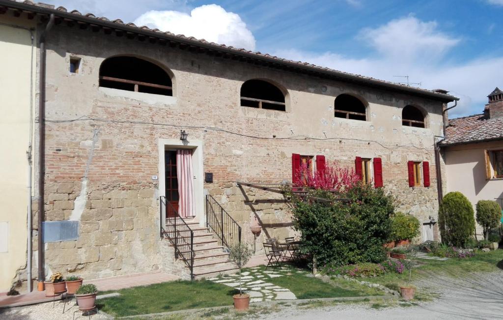 BadiaにあるCasa Badiaの赤いドアと窓のある古いレンガ造りの建物